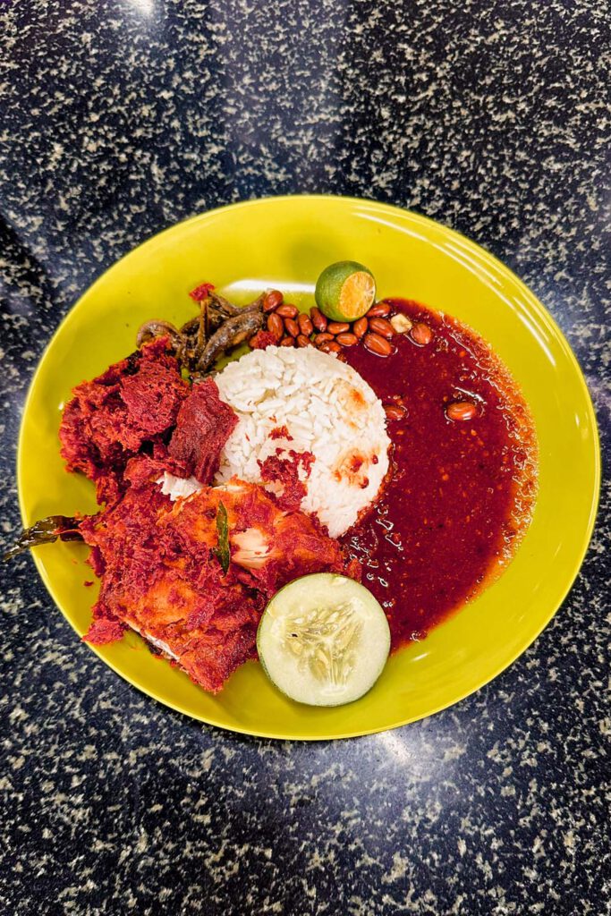 No Kuala Lumpur Travel Guide would be complete without the mention of Nasi Lemak. 
The typical Malaysian dish with rice, chicken, peanuts, lime, cucumber, and anchovies is simply too good to miss! 