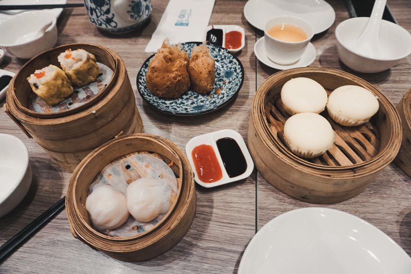 A table illed with a lot of plates with Dim Sum.