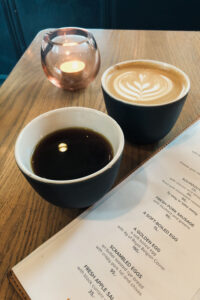 A wooden plate, with a candle, two coffees