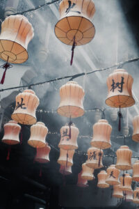 Picture of lanterns in Yu Yuan Temple, Shanghai. Due to food trucks steaming dumplings, the yellow lanterns are covered in fog. This gives the whole scenery a very moody atmosphere.