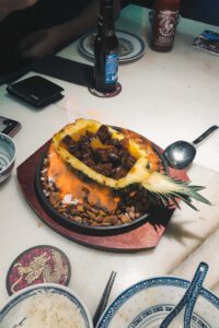 a burning pineapple with meat in it