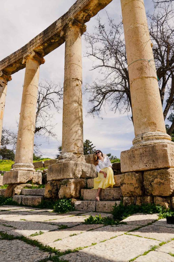 Girl sitting between some pillars in Jerash, Jordan