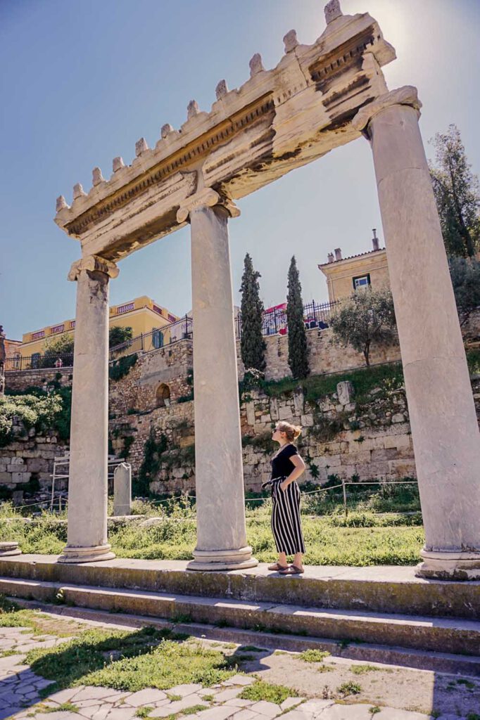 Girl standing underneath a Greek Arch