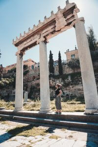 Girl standing underneath a Greek Arch