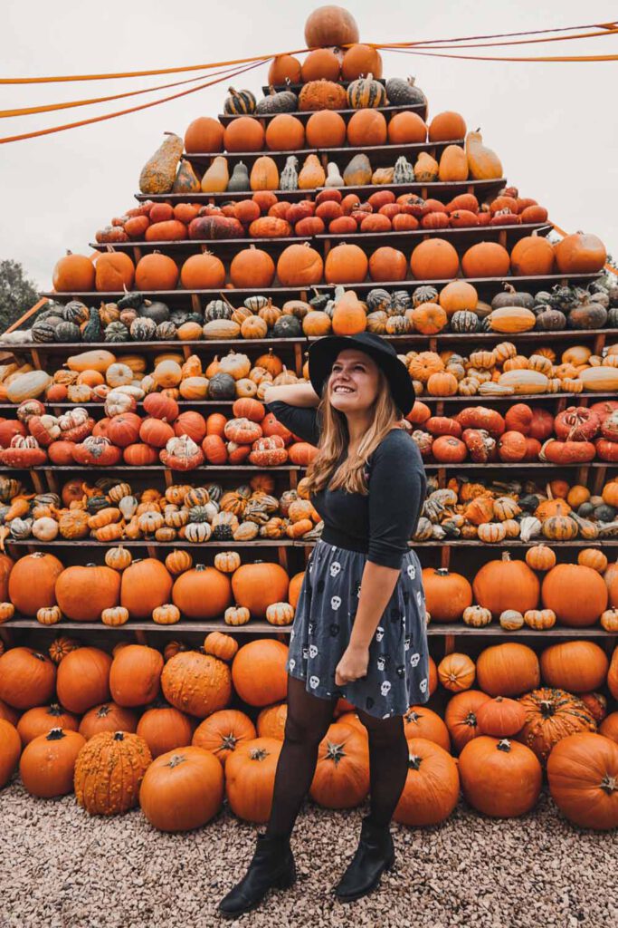 girl in front of a pumpkin pyramid