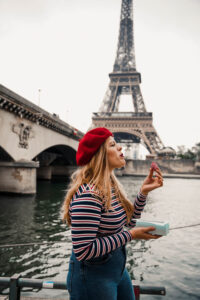 Weekend in Paris - Maison Laduree. I am standing next to the Seine in Paris, just in front of the Eiffel Tower. In a striped shirt and wearing a red beret, I am eating Macarons by Maison Ladurée. In my opinion, macarons by Ladurée are the best you can find in Paris!
