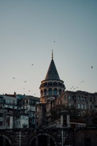 Galata Tower in the dusk with sea gulls flying around taken from Karaköy - Highlights of Istanbul